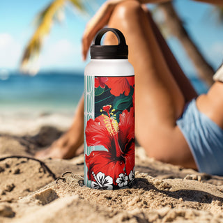 Hibiscus insulated water bottle by Studio Bilby sitting in the sand on a beach. Background of palm tree and women sunbathing.