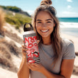Women on a beach holding the 'Kissable' insulated water bottle by Studio Bilby.