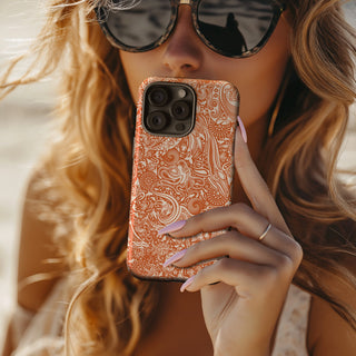 Women holding the 'Ocean Orange Dark' tough phone case by  Studio Bilby.