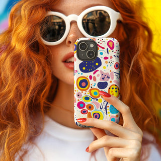 Women wearing white sunglasses holding the playful pizzazz tough phone case by Studio Bilby.